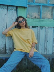 a woman in denim jeans and yellow shirt